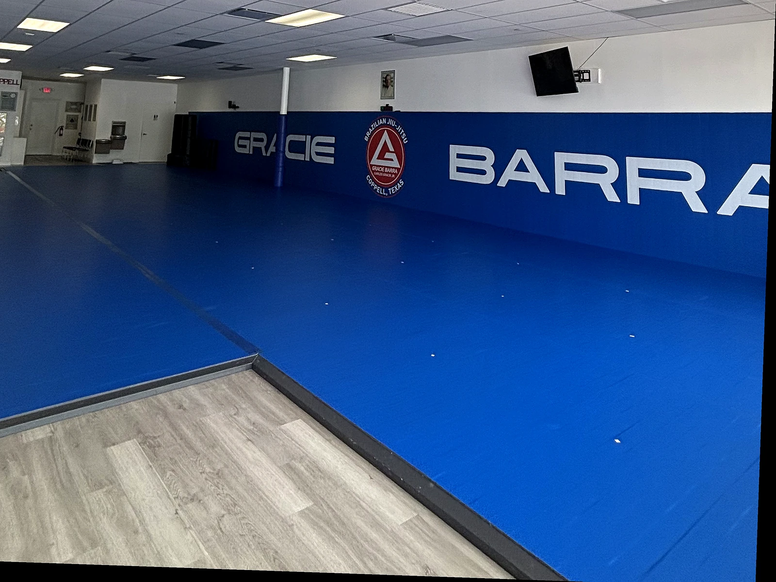 Blue mats and the Gracie Barra wall inside Gracie Barra Coppell
